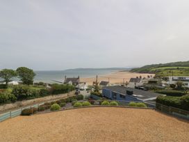 A view of the sea and beach with houses and trees at Hillside in 