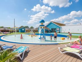 An outdoor pool area with a water slide at Tide’s Reach - Hayling Island Holiday Park