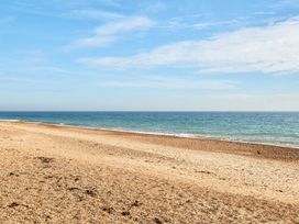 A beach with sand and ocean waves at Tide’s Reach - Hayling Island