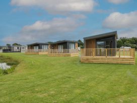 Three cabins with decks on grass at Heron in Haverigg
