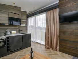 A kitchen with a sink, microwave, and oven at Heron in Haverigg