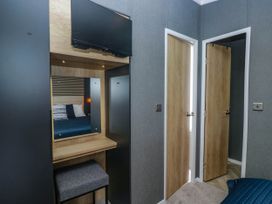 A bedroom with a television and mirror at Heron in Haverigg