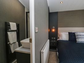 A bedroom with bed and washbasin at Heron in Haverigg