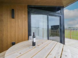 A table with a wine bottle and glasses on an outdoor veranda at Heron in Haverigg