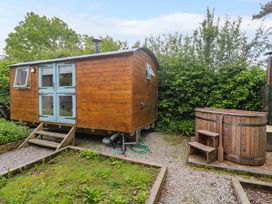 A wooden cabin with steps and a hot tub at Shepherds Hut in Truro