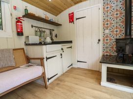 A kitchen with a sink and wood stove at Shepherds Hut in Truro