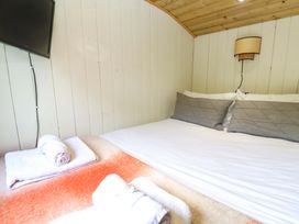 A bedroom with a bed and television at Shepherds Hut in Truro
