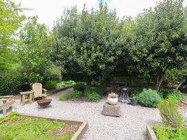 A garden with trees and gravel pathways at Shepherds Hut in Truro