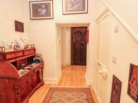 A hallway with a wooden cabinet and door at The School House in Penrith