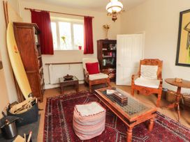 A living room with a surfboard and books on a shelf at The School House in Penrith