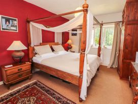 A bedroom with a four-poster bed and bedside table at The School House in Penrith