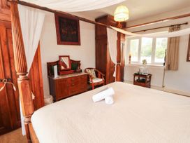 A bedroom with a bed and wooden furniture at The School House in Penrith