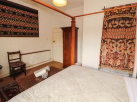 A bedroom with a bed and wall hanging at The School House in Penrith