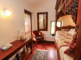 A bedroom with a carved bed and wooden furniture at The School House in Penrith