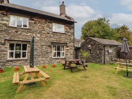 A garden with a stone house and picnic table at The School House in Patterdale near Glenridding
