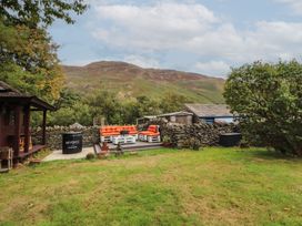A garden with outdoor furniture and a wooden structure at The School House Patterdale near Glenridding