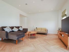 A living room with a sofa and television at Edens in Penwithick