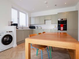 A kitchen with a table and chairs at Edens in Penwithick