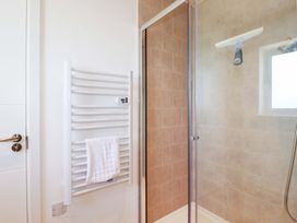 A bathroom with a shower and towel rack at Edens Penwithick