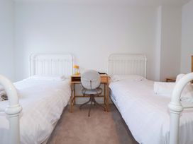 A bedroom with two beds and a desk at Edens in Penwithick