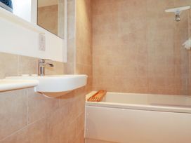 A bathroom with a sink and bath tub at Edens in Penwithick