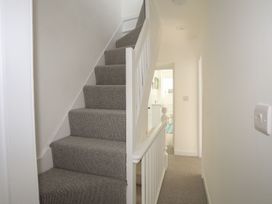 A hallway with carpeted stairs leading to a bathroom at Bodefi in Pwllheli