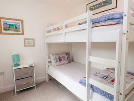 A bedroom with a bunk bed and nightstand at Bodefi in Pwllheli