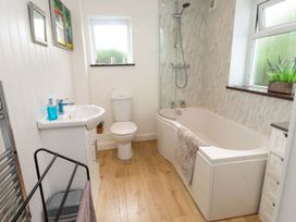 A bathroom with a bathtub, sink, and toilet at Bodefi in Pwllheli