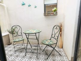 A patio with a table and chairs at Bodefi in Pwllheli