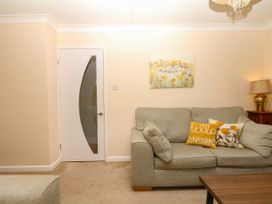 A living room with a sofa and lamp at Marldon Mews in Marldon