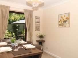 A dining room with a table set and flowers at Marldon Mews in Marldon