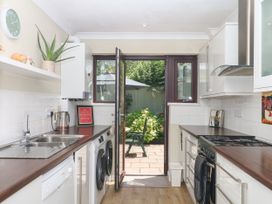 A kitchen with appliances and open door leading to garden at Marldon Mews in Marldon