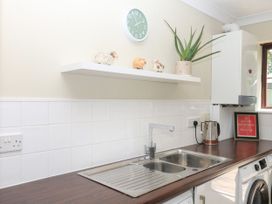 A kitchen with a sink and shelf at Marldon Mews in Marldon