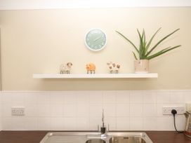 A kitchen with a clock and figurines on a shelf at Marldon Mews in Marldon