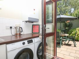 A kitchen with a washing machine and kettle at Marldon Mews in Marldon