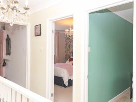 A hallway with chandeliers and doorways at Marldon Mews in Marldon