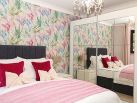 A bedroom with a bed and mirrored wardrobe at Marldon Mews in Marldon