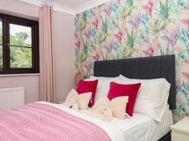 A bedroom with a bed and colorful wall at Marldon Mews in Marldon