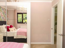 A bedroom with a bed and a mirror at Marldon Mews in Marldon