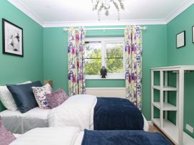 A bedroom with two beds and a shelf at Marldon Mews in Marldon