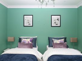 A bedroom with two beds and framed art at Marldon Mews in Marldon