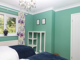 A bedroom with two beds and a window at Marldon Mews in Marldon