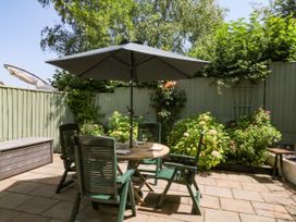 A garden with a table and chairs under an umbrella at Marldon Mews in Marldon