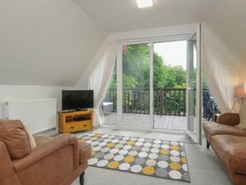 A living room with a television and sofa at 9 Honicombe Park in Callington