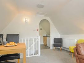 A living room with a dining table and kitchen access at 9 Honicombe Park Callington
