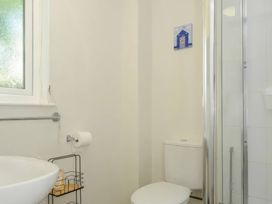 A bathroom with a washbasin, toilet, and shower at 9 Honicombe Park, Callington