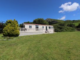 A trailer with deck in a grassy area at Mor a Mynydd in Pwllheli