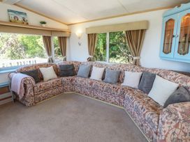 A living room with a sectional sofa and window at Mor a Mynydd in Pwllheli