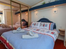 A bedroom with a double bed and towels at Mor a Mynydd in Pwllheli