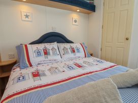 A bedroom with a bed and decorative bedding at Mor a Mynydd in Pwllheli